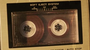 Retro teypte ses kaseti oynatıcısı. Eski şeffaf ses kasedini çalan bir pikap, yakın plan. Antika kasetler güvertede dönüyor. Konuşmalar kaydediliyor, 80 'ler, çağrı, retro çalma