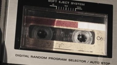 Retro teypte ses kaseti oynatıcısı. Eski sarı ses kasetini çalan bir pikap, yakın plan. Antika kasetler güvertede dönüyor. Konuşmalar kaydediliyor, 80 'ler, arama kaydı, retro çalma
