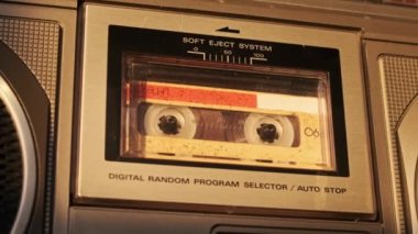 Retro teypte ses kaseti oynatıcısı. Eski sarı ses kasetini çalan bir pikap, yakın plan. Antika kasetler güvertede dönüyor. Konuşmalar kaydediliyor, 80 'ler, arama kaydı, retro çalma