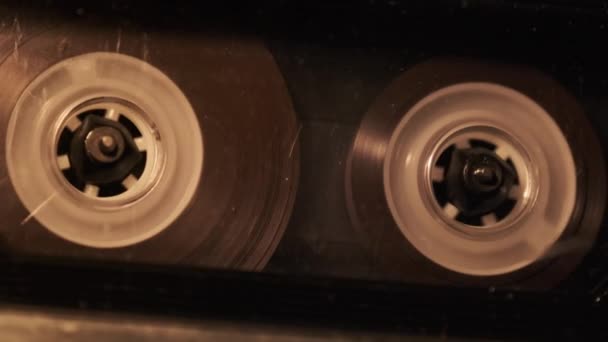 レトロなテープレコーダーでのオーディオカセット再生 古い透明なオーディオカセットをちらつきキャンドルライト クローズアップで再生しているレコードプレーヤー ヴィンテージテープリールがデッキで回転します 通話録音再生 — ストック動画