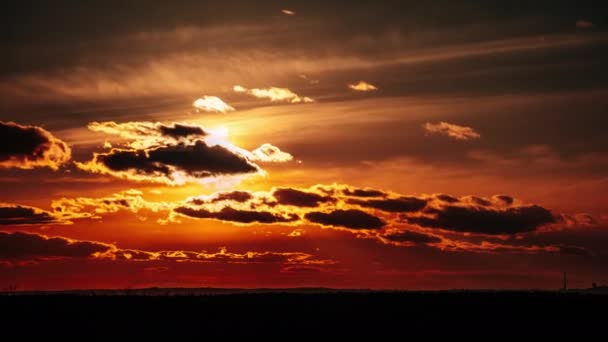 水平線上のオレンジ色の空の雲を通して劇的な日没の経過 太陽の光が降り注ぐ大きな赤い太陽 素晴らしい壮大な雲の空間 鮮やかな色 タイムラプス 黄色の空の日没 — ストック動画