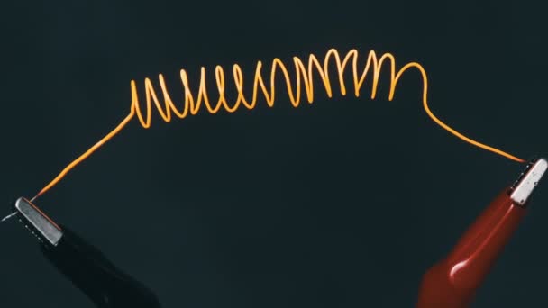 在高电流下 尼可洛梅金属丝在红色和红色之间发光 尼可洛梅长丝呈螺旋状连接在电线上 电线发光 金属电阻高 目前的兵力 实验室测试及特写 — 图库视频影像