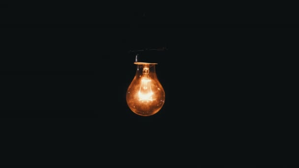 Hanging Incandescent Bulb Turns Flickers Black Background Place Text Warm — Stok Video