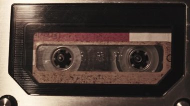Retro bir teypte ses kaydı oynatılıyor. Plak çalar, yanıp sönen mum ışığında eski sarı bir kaset çalar, yakın plan. Eski bant makaraları güvertede dönüyor. Arama kaydı, çalma, 80 'ler