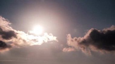 Turuncu bulutların arasından gökyüzünde güneş ışınlarıyla dramatik günbatımının zamanı. Büyük parlak turuncu güneş ufukta aşağı doğru hareket ediyor. Müthiş destansı bulut uzayı, canlı bir renk. Zaman aşımı. Gün batımı. 4K