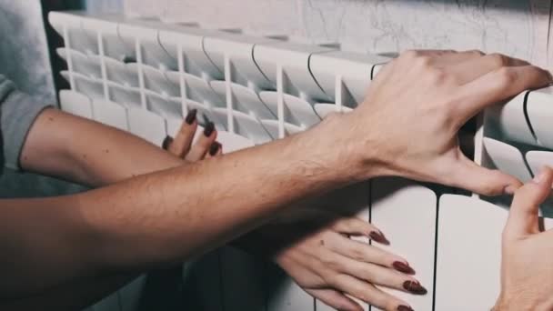 Frysta Manliga Och Kvinnliga Händer Vidrör Värmeelementet Och Försöker Värma — Stockvideo