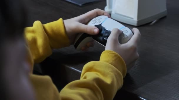 游戏在游戏控制台上 青少年坐在桌子旁边 靠得很近 手里握着一根操纵杆 男孩在娱乐中心的游戏区使用视频游戏控制器 游戏玩家玩电子游戏 — 图库视频影像
