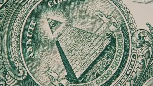 全眼サインのメイソンサインシンボルは 1ドル札のクローズアップで回転します 上にピラミッドと目を持つマクロの米国銀行券 新しい世界秩序エリート 概念インフレ経済陰謀 — ストック動画