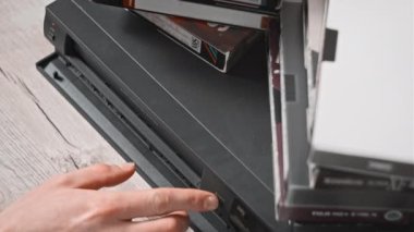 Video oynatıcıdan VHS kaseti çıkar. Erkek el, birçok arşivlenmiş video kaset içeren eski bir video kayıt cihazından VHS çekiyor. VHS retro oynatıcı. Ev videosu kavramı, eski teknoloji