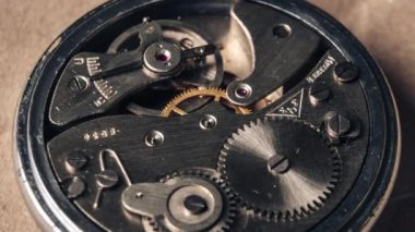 Saat mekanizmasının zamanlaması yakın plan. Klasik yuvarlak saat mekanizması makroda çalışıyor ve dönüyor. Eski çarklar, dişliler ve sarkaçlar antik kronometrenin içinde..