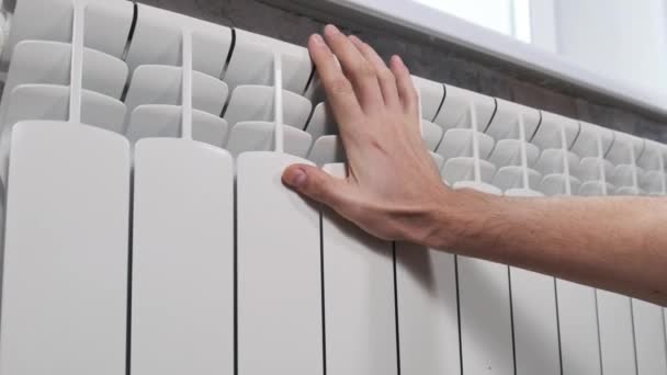 男性の手は壁に冷たい加熱ラジエーターに触れます パームは家の暖房システムを暖めようとしている 貧しい暖房システムの概念 アパートで寒い 冬の季節 — ストック動画