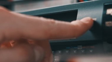 Video oynatıcıdan VHS kaseti çıkar. Erkek el bir düğmeye basar ve birçok arşivlenmiş video kasetle birlikte masadaki klasik video kayıt cihazından VHS 'yi çıkarır. VHS retro oynatıcı. Ev videosu, eski kaset