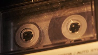 Teypte kaset oynatılıyor. Yakın plan. Güvertede çalan ve döndüren şeffaf ses kaseti. Eski retro kaydediciyle klasik ses kaydı. Kaydı ara. Ses kaydı oynatıcısı, Macro