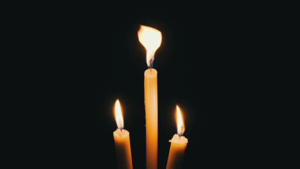 Три Свічки Горять Чорному Тлі Зблизька Ізольовані Жовті Вогні Мерехтять — стокове відео