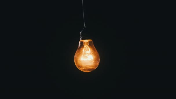 エジソンランプが立ち上がり 黒い背景でちらつきます 電球がオンとオフのクローズアップをオンにしました 暖かい点滅フィラメント ヴィンテージライトのタングステン電球光と居心地の良い輝き アイデア コピースペース — ストック動画
