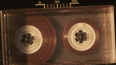 Klasik kayıt cihazında ses kasedi oynatıcısı. Eski şeffaf ses kasedini çalan bir pikap, yakın plan. Retro bantlar güvertede dönüyor. Konuşmalar kaydediliyor, 80 'ler, arşiv kaydı, çağrı