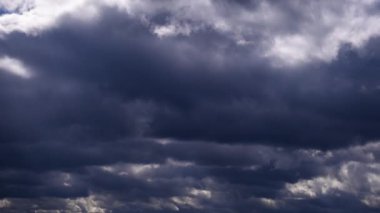 Gökyüzünde hareket eden fırtına bulutlarının zamanı. Karanlık, aydınlık ve gri kümülüs bulutlarının şekil değiştirdiği, zaman atlamalı bulutlu bir arka plan. Hava değişikliği. Doğa, gökyüzü bulutları, kopyalama alanı, atmosfer