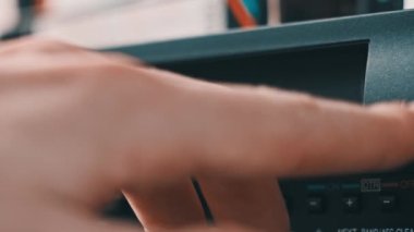 Video oynatıcıdan VHS kaseti çıkar. Erkek el bir düğmeye basar ve birçok arşivlenmiş video kasetle birlikte masadaki klasik video kayıt cihazından VHS 'yi çıkarır. VHS retro oynatıcı. Ev videosu, eski kaset