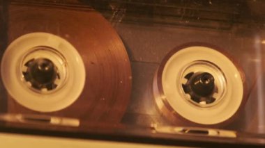 Retro teypte ses kaseti oynatıcısı. Eski şeffaf ses kasedini çalan bir pikap, yakın plan. Antika kasetler güvertede dönüyor. Konuşmalar kaydediliyor, 80 'ler, çağrı, retro çalma