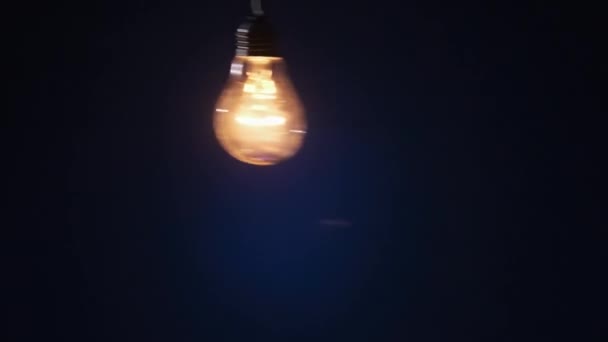 Incandescent Lamp Wire Sways Side Side Lights Flickers Dark Blue — 图库视频影像