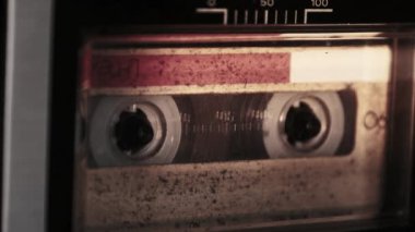 Retro teypte ses kaseti oynatıcısı. Eski sarı ses kasetini çalan bir pikap, yakın plan. Antika kasetler güvertede dönüyor. Konuşmalar kaydediliyor, 80 'ler, arama kaydı, retro çalma