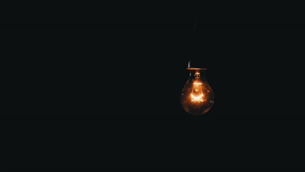 Hanging Incandescent Bulb Turns Flickers Black Background Place Text Warm — Video Stock