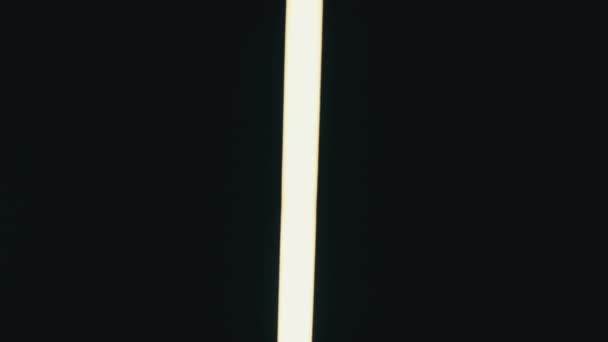 霓虹灯Led剑在黑色背景下左右移动 管状手电筒的明亮的白光 视频转换效果 发光的霓虹灯 抽象的荧光背景 — 图库视频影像