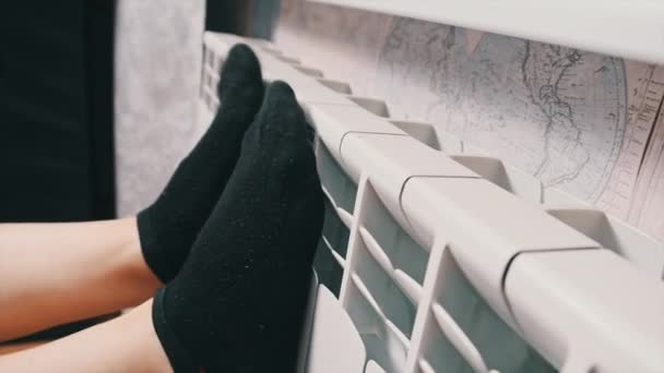 穿着袜子的雌性腿碰了碰暖气散热器 试图保暖 供热系统的概念差 公寓冷 供热问题 中央供热 冷的人试着取暖 — 图库视频影像
