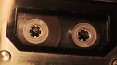 Kaset, titreyen yumuşak ışıkta, yakın planda bir teypte çalınır. Güvertedeki şeffaf ses kaseti dönüyor. Eski bir retro çalgıcıda klasik ses kaydı. Ses Kasedi oynatıcısı