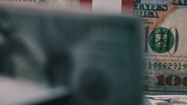 10 bin Amerikan Doları demetleri banknotlar halinde masanın üzerinde dönüyor. 100 dolarlık banknotlar. Dolarlar yakın plan çekimde dönüyor. Makro olarak yığınla para. Büyük paralar, iş yatırımları. 4K