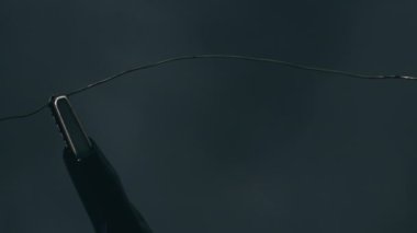 Güç kablolarına bağlı nikrome kablosu yüksek akım altında kırmızıya ısıtılır. Elektrik kabloları havayı ısıtıyor ve arka planda parlıyor. Yüksek metal direnci. Güç gücü. Kısa devre. Yakın plan.