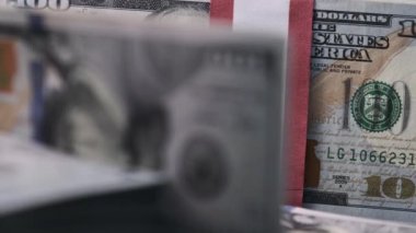 Dolarlar yakın planda toplanır. 10 bin Amerikan Doları demetleri banknotlar halinde masanın üzerinde dönüyor. 100 dolarlık banknotlar. Makro olarak yığınla para, büyük para, iş yatırımı. 4K