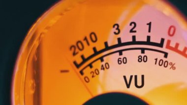 Sarı arka ışıklandırmalı ses sinyali seviyesinin klasik analog ok göstergesi. Analog VU ölçere yakın çekim. Retro ekipman, müzik çalma ya da kayıt. Ses düzeyi ile ses düzeyi senkronize ediliyor