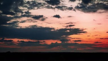 Gün batımından sonra ufkun üzerindeki turuncu gökyüzünde hareket eden stratus bulutlarıyla, Timelapse. Destansı bulut uzayı, Zaman Hızı. Güzel bir akşam, alacakaranlık, arka plan.