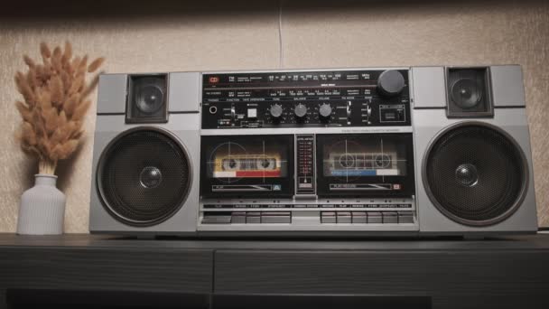 古いラジオのBoomboxプレーヤーでオーディオカセットを再生し 聞いてください レトロステレオラジオテープレコーダーのクローズアップ 男の手は 再生ボタンを押して音楽を聴く ヴィンテージ2カセットラジオプレーヤー — ストック動画