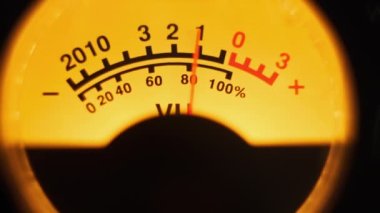 Sarı arka ışıklandırmalı ses sinyali seviyesinin klasik analog ok göstergesi. Analog VU ölçere yakın çekim. Retro ekipman, müzik çalma ya da kayıt. Ses düzeyi ile ses düzeyi senkronize ediliyor