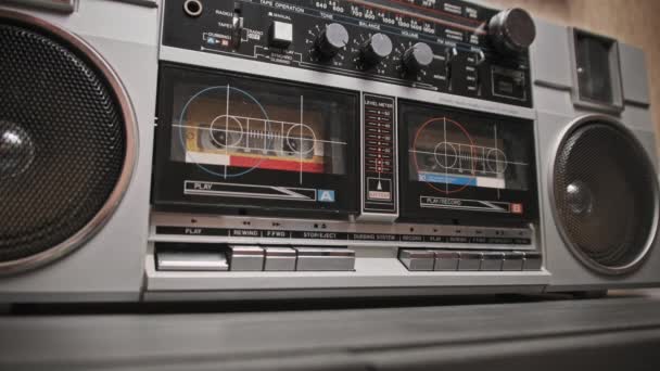 在桌上用老式盒式机播放盒式磁带 男性按下桌子上两个盒式磁带唱机上的播放按钮 听音乐 80年代带扬声器的银复古收音机 — 图库视频影像