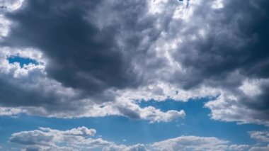 Kümülüs bulutları mavi gökyüzünde hareket eder, zaman kavramı. Gri ve yumuşak beyaz bulutların arka planı bulutlu uzayda şekil değiştirir. Zaman atlamalı hava değişikliği. Doğal arka plan, kopyalama alanı. 4K