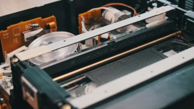 VHS video kaseti bir video kaydedicinin içine yerleştiriliyor ve oynatılıyor. Video kasetin klasik VHS mekanizması video başına bant takar. Retro video kaset bir video kasetinde döner. Eski bir film oynuyorum, yayın yapıyorum..