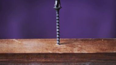 Vidası tahta tahtaya tornavidayla vidalanmış. Aşırı makro. Uzayı kopyala Elektrikli matkapla vidayı sıkma işlemi. Tahtadaki koltuğa vidalanan vidayı yakın plan.