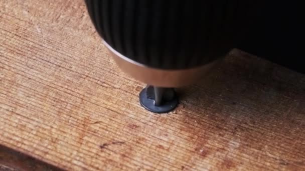 用螺丝刀把螺丝从木块上拧下来的特写 工匠们用宏观上的电钻拧出一个木制的自攻螺钉 螺丝旋转 — 图库视频影像