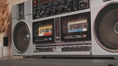 Klasik bir teypten müzik. Eski bir ses kasedinin analog sesi. Masadaki iki kaset çalar üzerindeki erkek el ile oynatma düğmesine bas ve müzik dinle. 80 'lerden kalma bir teyp kaydı.