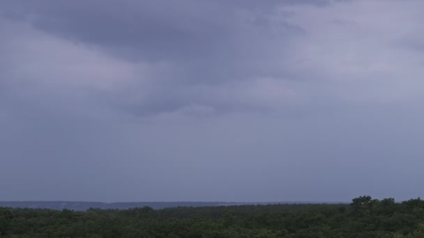 暴风雨云中闪烁着闪电 厚重的云彩带来了多次闪电和雷雨 在森林地平线上方的夜空中 巨大的闪电击中了地面 慢动作4K — 图库视频影像