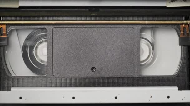 Vhs盒式磁带在Vcr录音机内播放 顶部观看 录像带卷旋转 带有空白标签的盒式磁带正在开始回放 在特写镜头里的旧录像机播放老式电影 — 图库视频影像