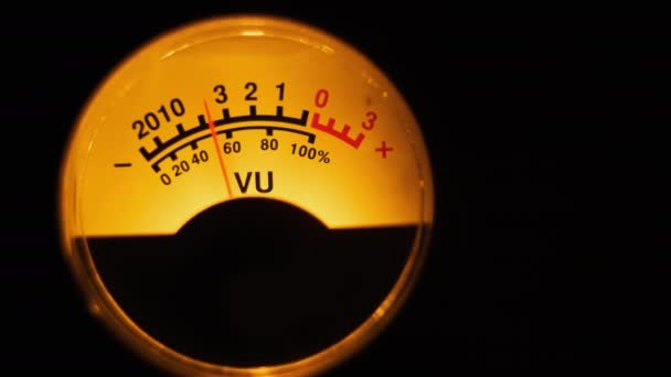 オーディオ信号レベルのアナログダイヤルインジケータ ヴィンテージの矢印は サウンドレベルと同期して移動します 黄色のバックライト Vuメートルとラウンド古典的なボリュームインジケータ 古いゲージ測定Dbデシベルのクローズアップ — ストック動画