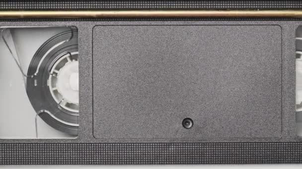 Vhsカセットは Vcrテープレコーダー トップビュー内で再生されます 動画リールが回転します 空の空白のタグを持つビデオカセットが再生を開始しています クローズアップ内の古いビデオレコーダー ヴィンテージ映画の再生 — ストック動画