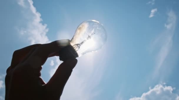 태양에 대하여 하늘에 전구를 투명한 램프를 인간의 Pov 실루엣 에너지 — 비디오