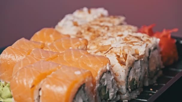 プラスチック製の箱の中の寿司ロールは クローズアップを回転させます 新鮮な日本のロール わさびを配達プラスチック容器に回転させた寿司ボックス コンセプトアジア料理 テイクアウト食品 健康的な食事 — ストック動画