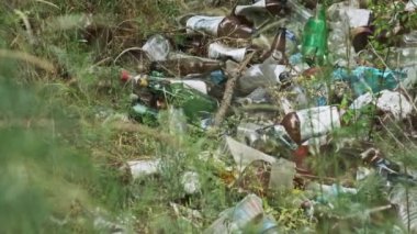 Ormanda plastik ve şişe çöplüğü var. Doğadaki sentetik atık yığını, çevre sorunları. Yasa dışı çöpler yere dökülüyor. Orman çukuruna bir sürü çöp atıldı. Ekolojik felaket