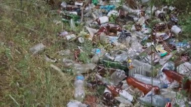 Ormanda plastik ve şişe çöplüğü var. Doğadaki sentetik atık yığını, çevre sorunları. Yasa dışı çöpler yere dökülüyor. Orman çukuruna bir sürü çöp atıldı. Ekolojik felaket